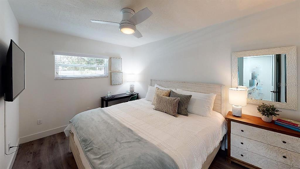 1912 Morrill Street, Unit LIME Sarasota, FL 34236 - Photo 23 of 34 a bedroom with a large bed and a flat tv screen on dresser