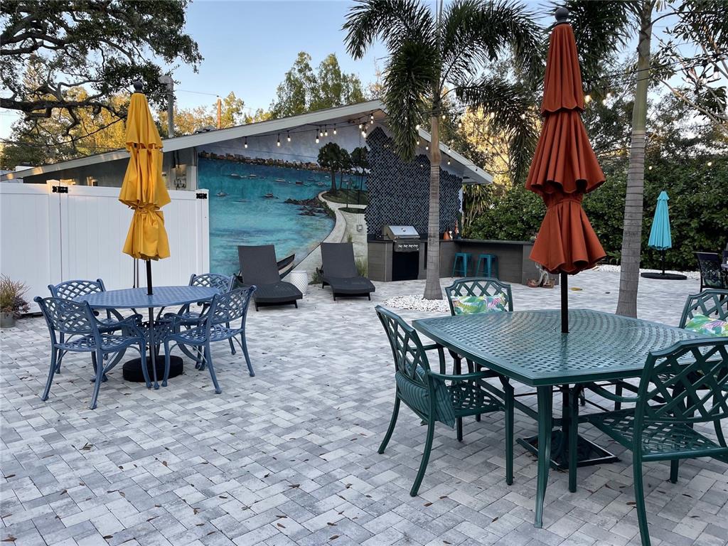 1912 Morrill Street, Unit LIME Sarasota, FL 34236 - Photo 26 of 34 a view of a backyard with table and chairs potted plants and a large tree