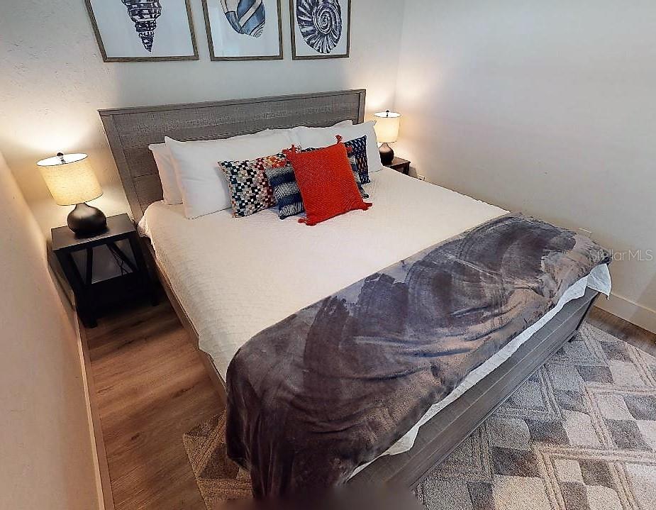 1912 Morrill Street, Unit LIME Sarasota, FL 34236 - Photo 33 of 34 a bed sitting in a bedroom next to a lamp