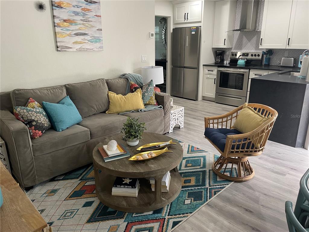 1912 Morrill Street, Unit LIME Sarasota, FL 34236 - Photo 8 of 34 a living room with furniture a refrigerator and a dining table with wooden floor