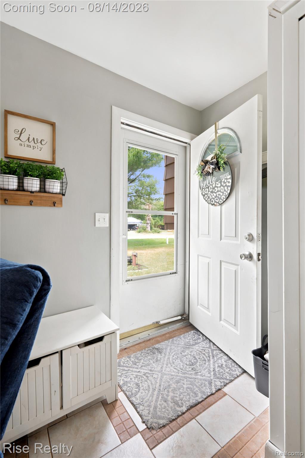 10215 West Frances Road Flushing, MI 48433 - Photo 3 of 31 White paneled entry door with an arched transom window, light gray wall paint, and a tiled flooring entrance