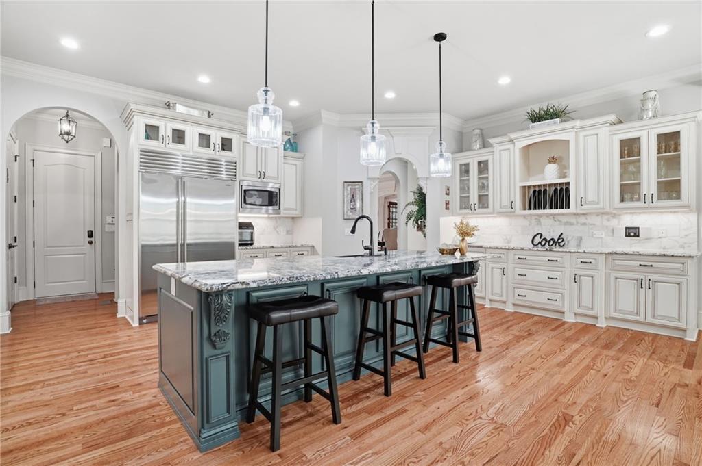 8340 Colonial Place Duluth, GA 30097 - Photo 10 of 74 a kitchen with granite countertop a table chairs stove a refrigerator and cabinets