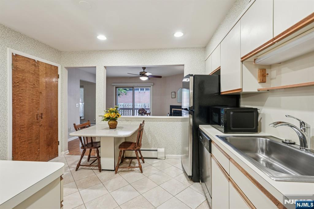 29 Ponds Circle, Unit 15 Wayne, NJ 07470 - Photo 20 of 47 a kitchen with stainless steel appliances a sink a stove a refrigerator cabinets and dining table