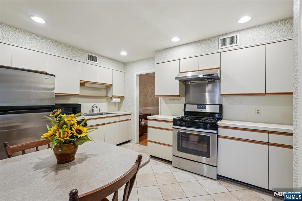 29 Ponds Circle, Unit 15 Wayne, NJ 07470 - Photo 23 of 47 a kitchen with a sink stainless steel appliances and white cabinets