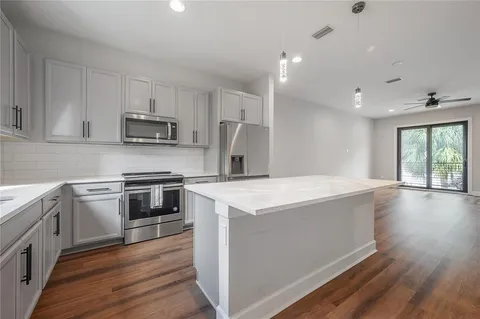 a kitchen with kitchen island granite countertop a stove a sink and a refrigerator