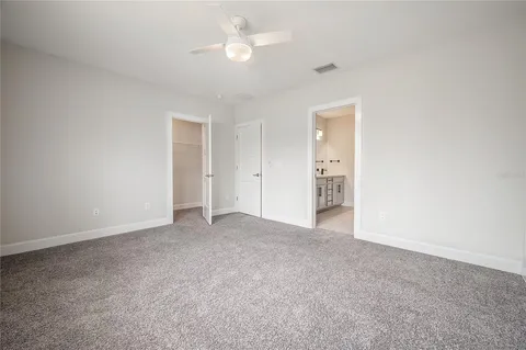 an empty room with fan and entrance