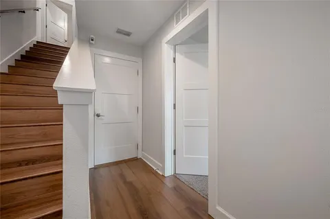 a view of a hallway with wooden floor and entryway
