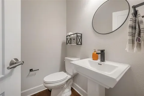 a bathroom with a sink a toilet and a mirror