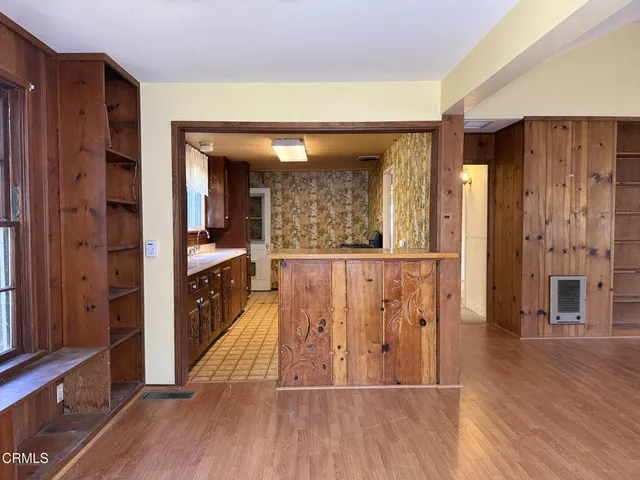 a view of a hallway with wooden floor and windows