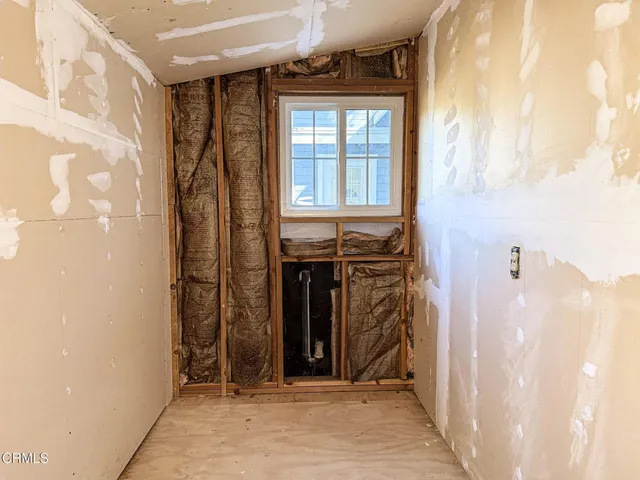 an empty room with windows and fireplace