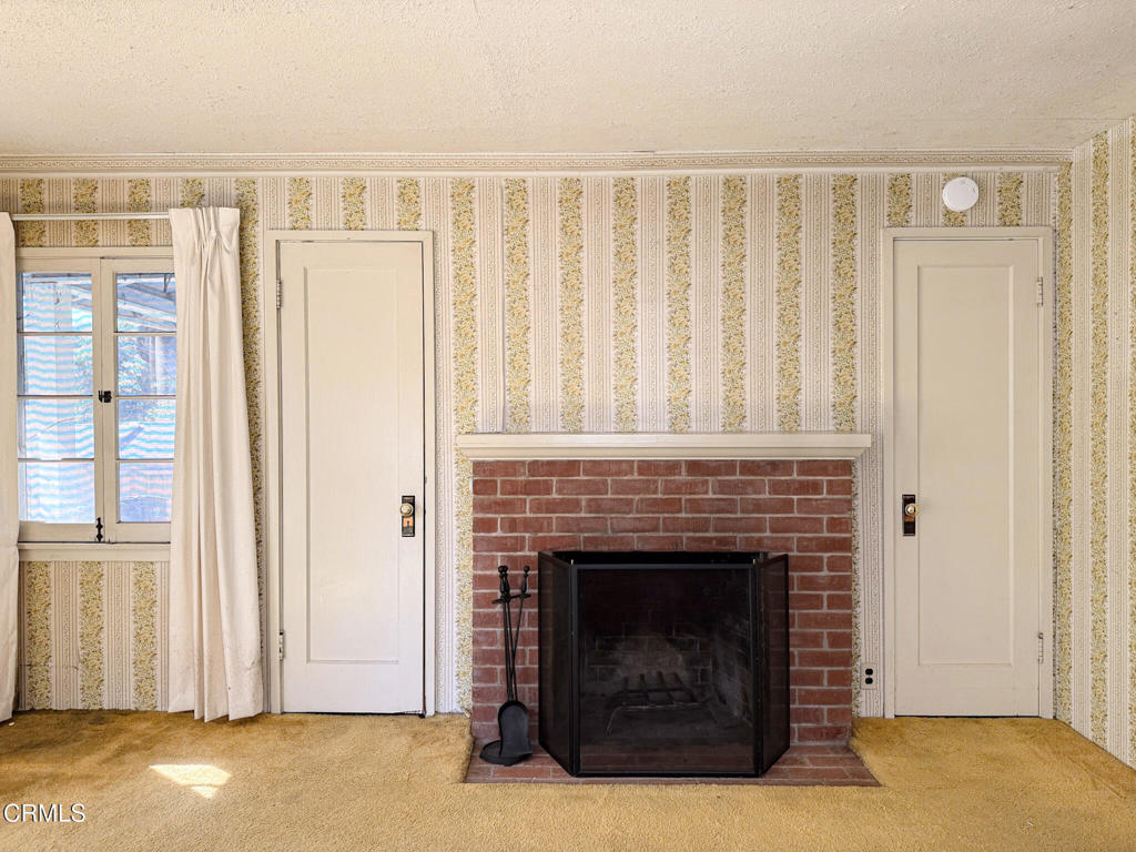 561 Tico Road Ojai, CA 93023 - Photo 27 of 59 a living room with furniture a fireplace and a window