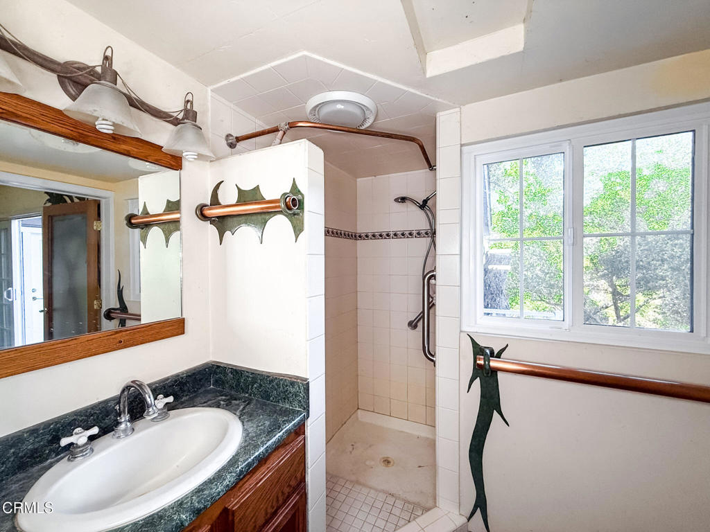 561 Tico Road Ojai, CA 93023 - Photo 40 of 59 a bathroom with a sink and mirror with bathtub