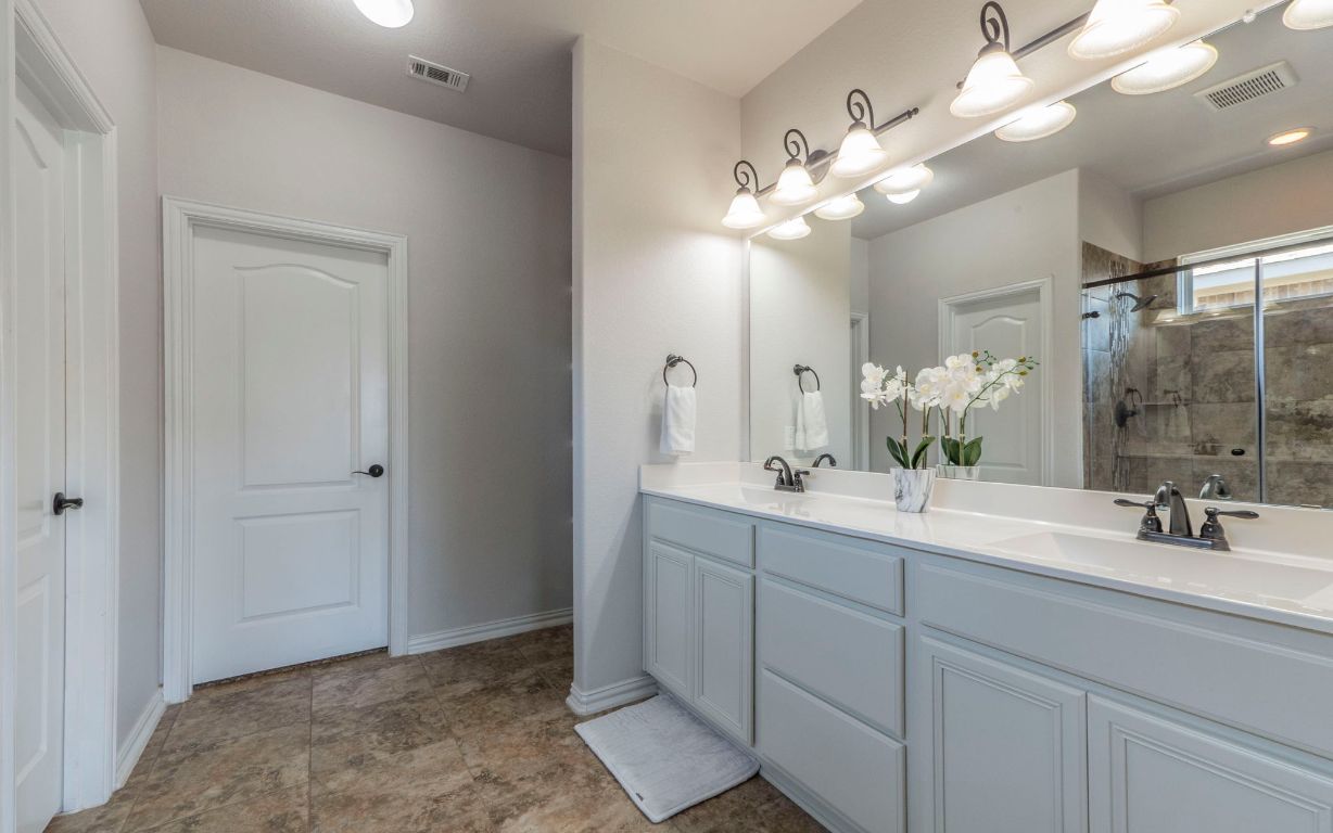 105 Penna Lane Georgetown, TX 78628 - Photo 17 of 39 a bathroom with a double vanity sink and a mirror