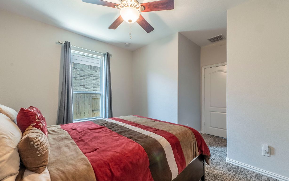 105 Penna Lane Georgetown, TX 78628 - Photo 20 of 39 a bedroom with a bed and a chandelier