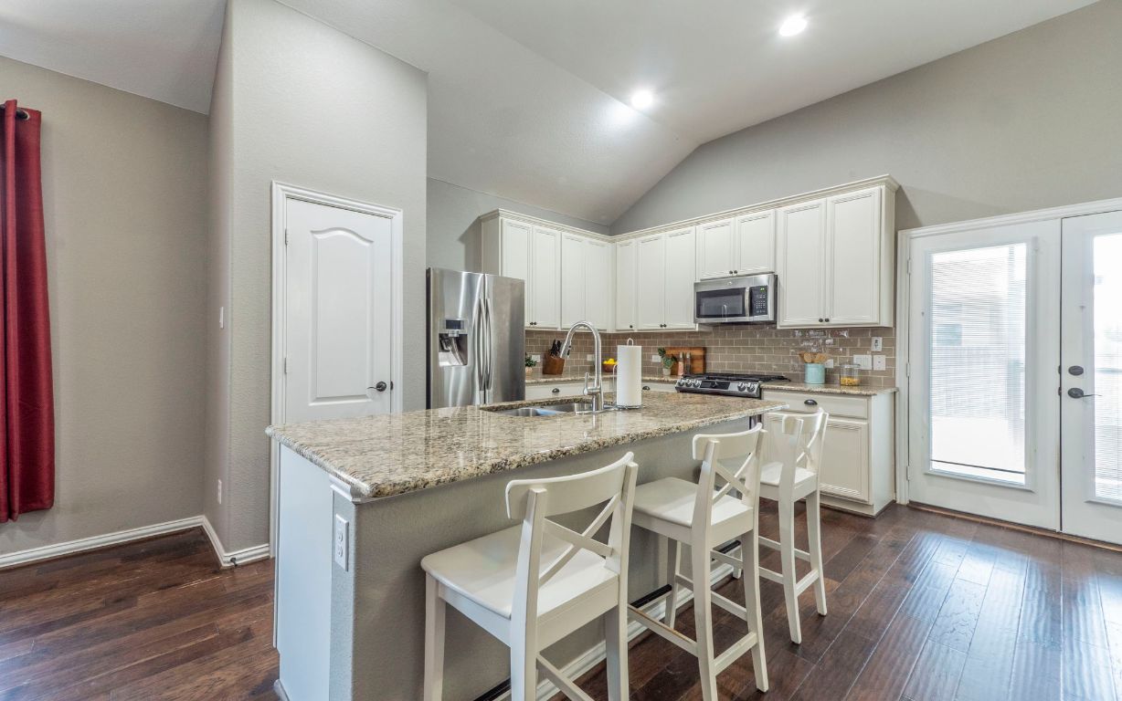 105 Penna Lane Georgetown, TX 78628 - Photo 2 of 39 a kitchen with stainless steel appliances granite countertop a stove top oven a sink and cabinets