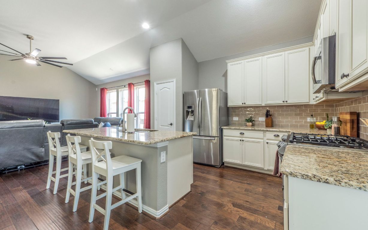 105 Penna Lane Georgetown, TX 78628 - Photo 9 of 39 a kitchen with stainless steel appliances granite countertop a white cabinets and a refrigerator