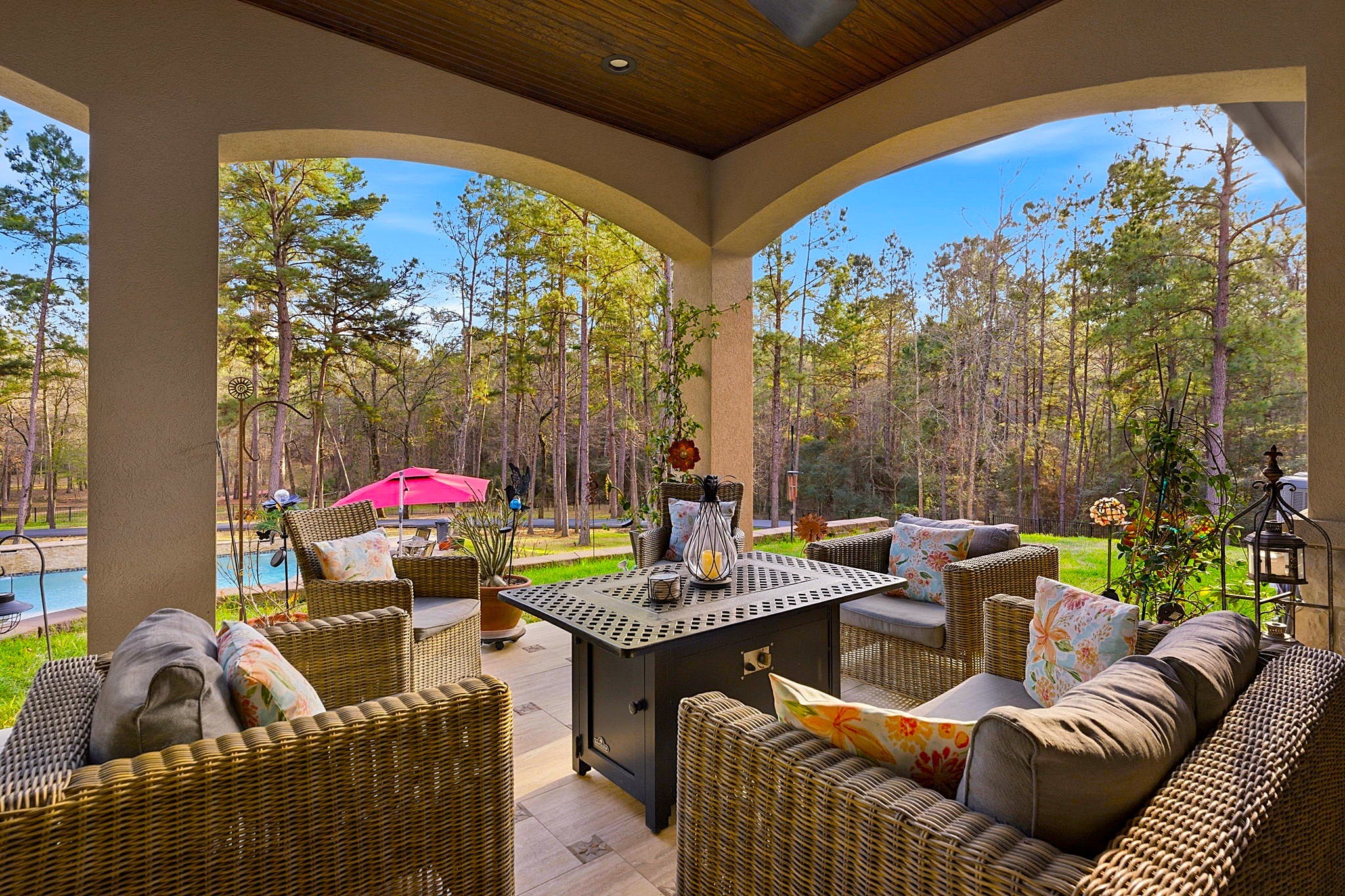 280 Sundog Road Huntsville, TX 77340 - Photo 40 of 50 Covered back patio just off the family room features wood ceilings, graceful arches, comfortable seating, and beautiful views of the pool and backyard, plus a convenient outdoor half bath serving the patio and pool area.
