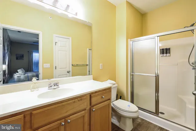 a bathroom with a sink a toilet a mirror and shower