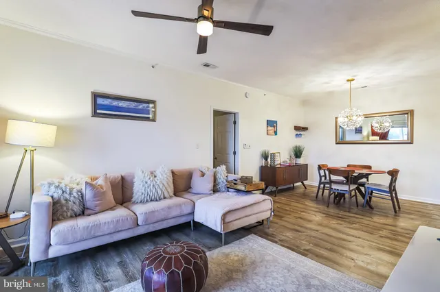 a living room with furniture a rug and a lamp