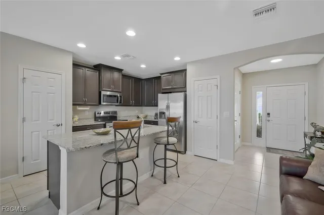 a kitchen with stainless steel appliances kitchen island granite countertop a refrigerator and cabinets