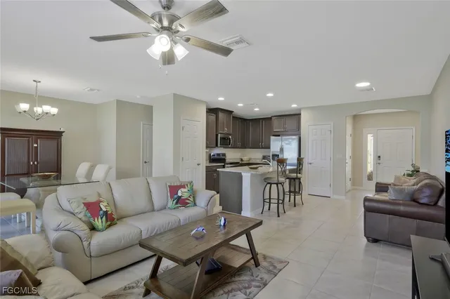 a living room with furniture kitchen view and a chandelier
