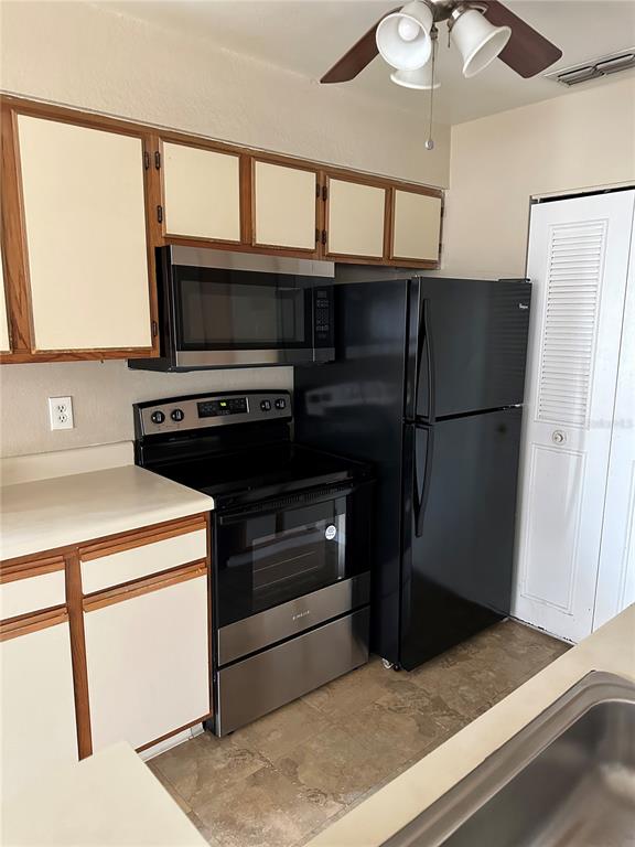 1065 South Hiawassee Road, Unit 1417 Orlando, FL 32835 - Photo 11 of 13 a kitchen with a refrigerator an oven and cabinets