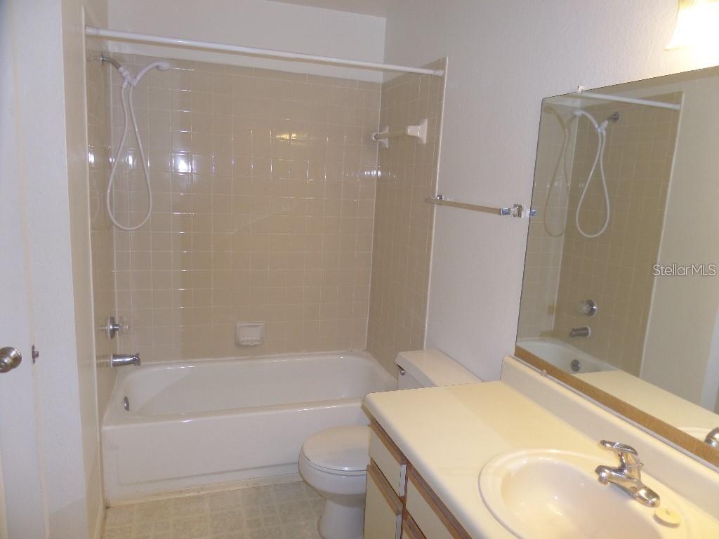 1065 South Hiawassee Road, Unit 1417 Orlando, FL 32835 - Photo 3 of 13 a bathroom with a sink toilet and shower