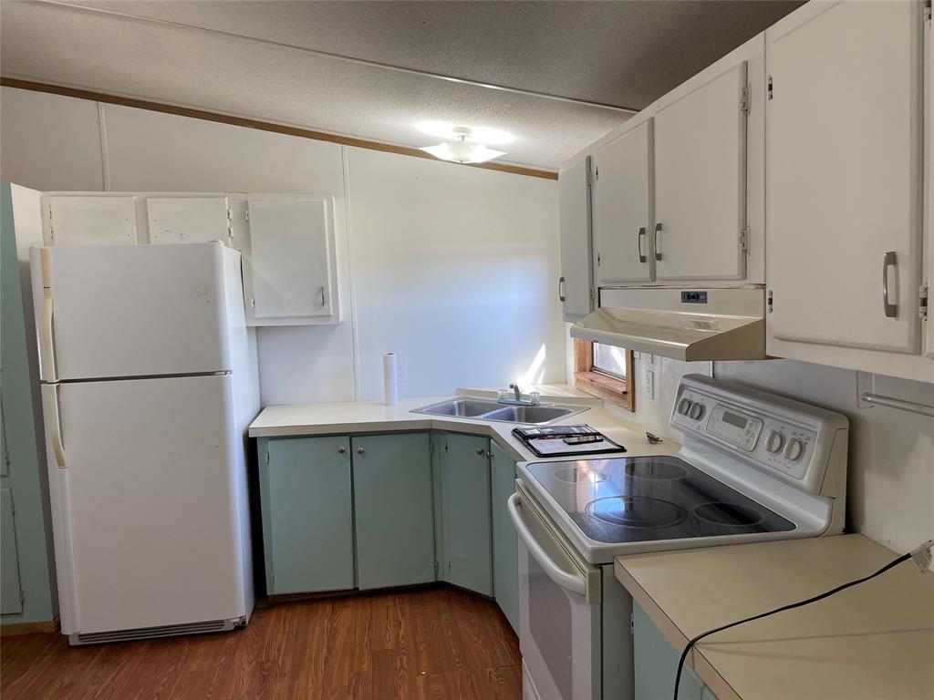 369 Private Road, Unit 4521 Wolfe City, TX 75496 - Photo 17 of 23 a kitchen with a stove and a refrigerator