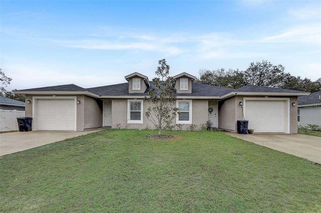 5 Rainbow Lane Palm Coast, FL 32164 - Photo 1 of 16 a front view of a house with a garden and yard