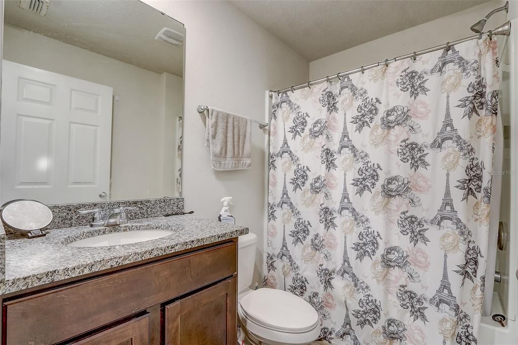 5 Rainbow Lane Palm Coast, FL 32164 - Photo 12 of 16 a bathroom with a granite countertop sink toilet mirror and shower