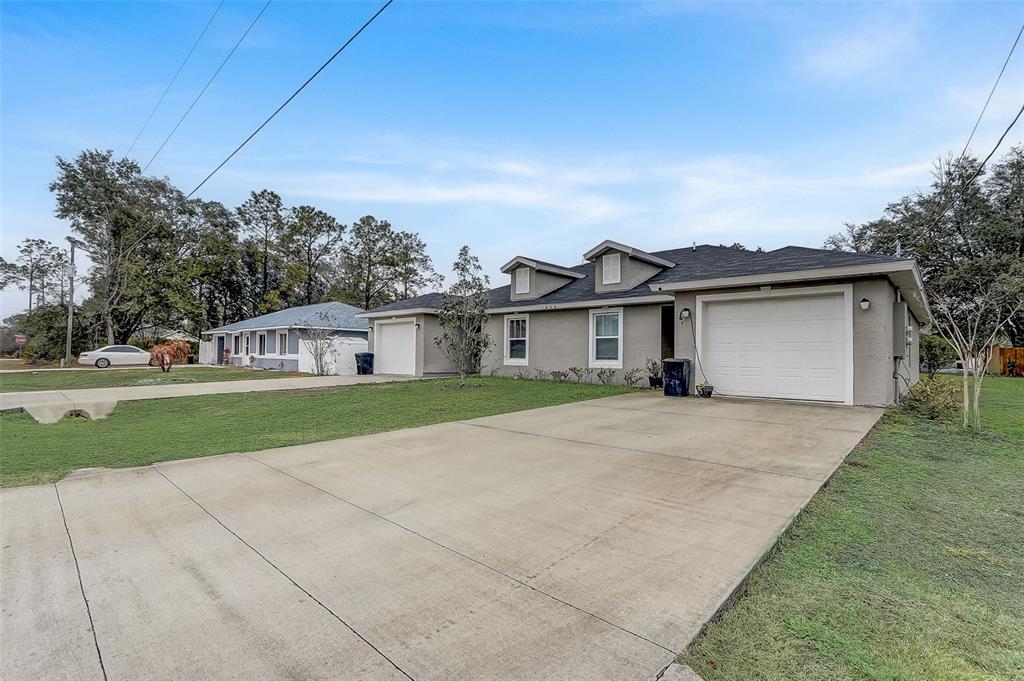 5 Rainbow Lane Palm Coast, FL 32164 - Photo 2 of 16 a view of house in front of a big yard with potted plants