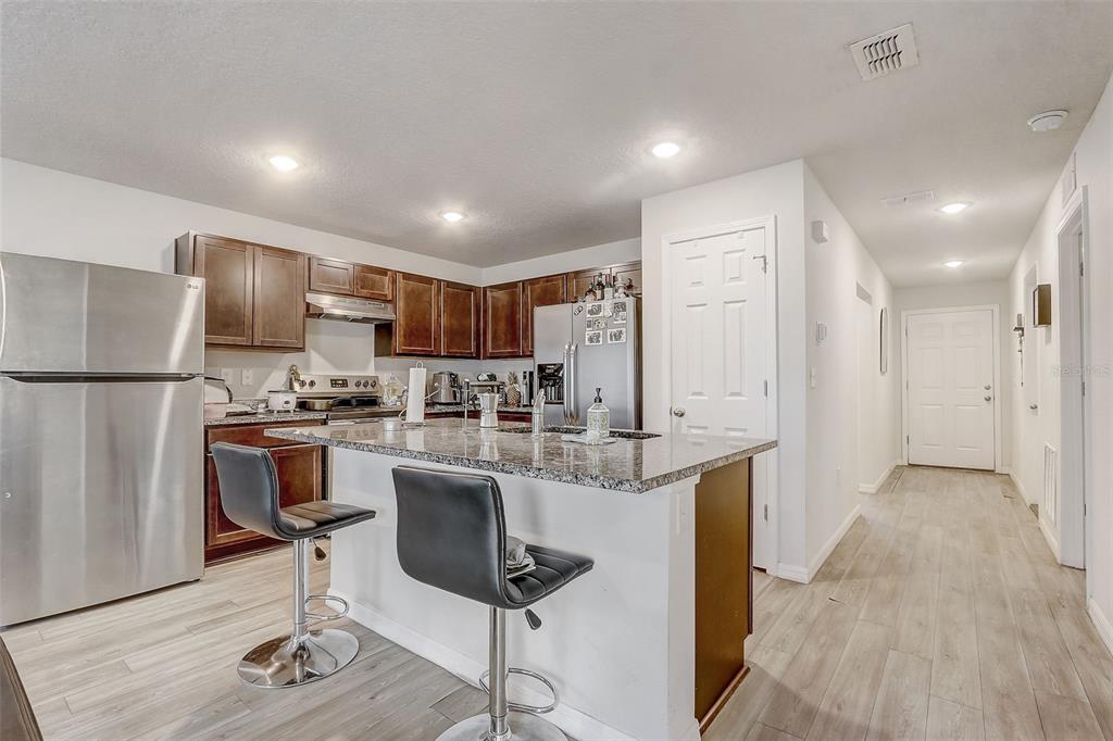 5 Rainbow Lane Palm Coast, FL 32164 - Photo 4 of 16 a kitchen with stainless steel appliances kitchen island granite countertop a refrigerator and a stove top oven