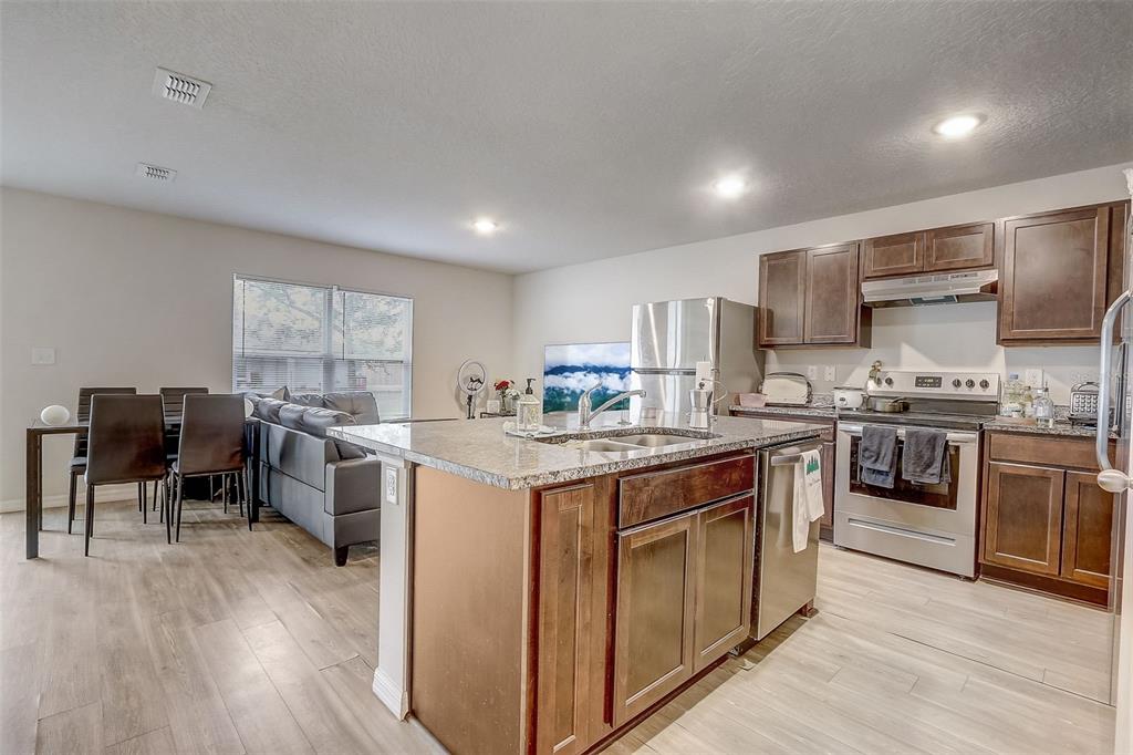 5 Rainbow Lane Palm Coast, FL 32164 - Photo 5 of 16 a kitchen with kitchen island granite countertop wooden floors stainless steel appliances and dining table
