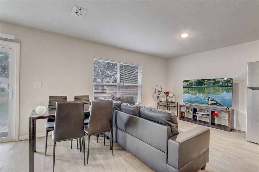 5 Rainbow Lane Palm Coast, FL 32164 - Photo 7 of 16 a living room with furniture a large window and a flat screen tv