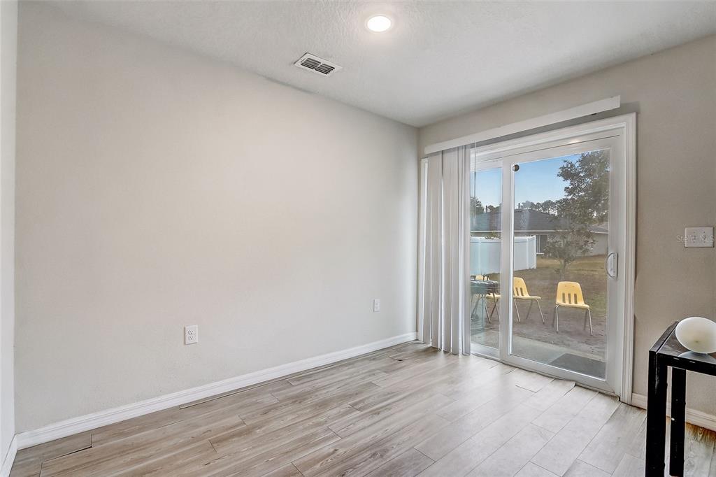 5 Rainbow Lane Palm Coast, FL 32164 - Photo 8 of 16 wooden floor in an empty room with a window