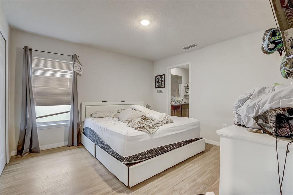 5 Rainbow Lane Palm Coast, FL 32164 - Photo 9 of 16 a white bed sitting in a bedroom next to a window