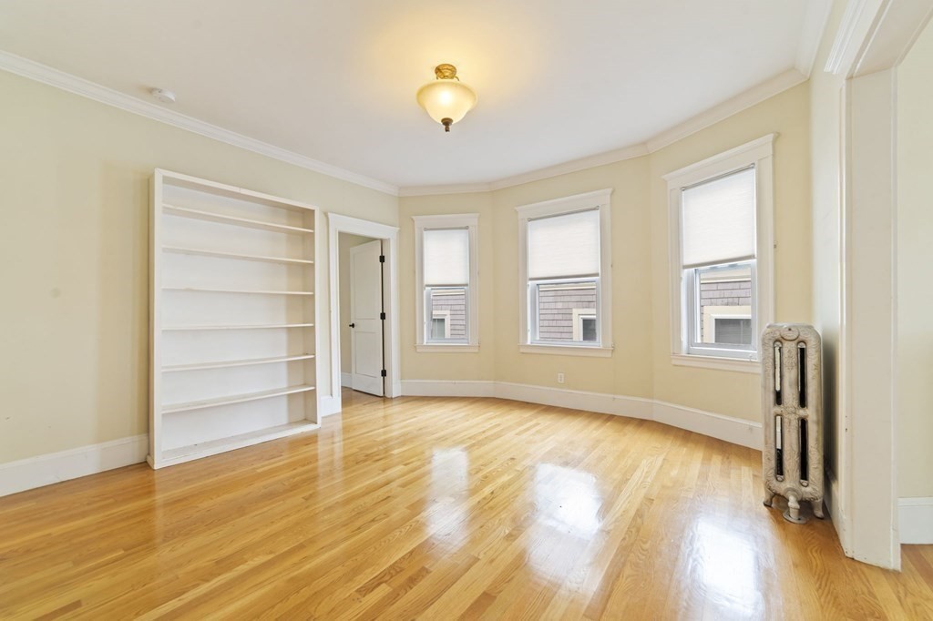 81 Montebello Road, Unit 3 Boston, MA 02130 - Photo 3 of 20 a view of an empty room with a window and wooden floor
