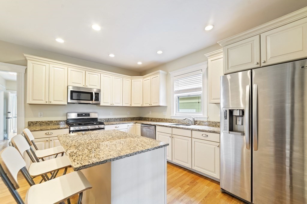 81 Montebello Road, Unit 3 Boston, MA 02130 - Photo 9 of 20 a kitchen with stainless steel appliances granite countertop a refrigerator sink stove and microwave