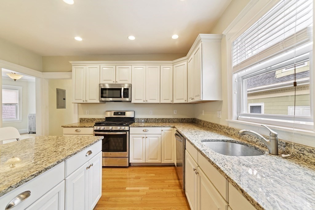 81 Montebello Road, Unit 3 Boston, MA 02130 - Photo 10 of 20 a kitchen with granite countertop stainless steel appliances stove microwave sink and cabinets
