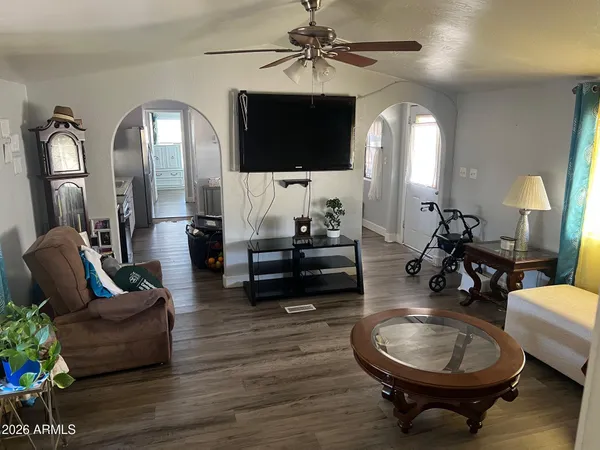 a living room with furniture a flat screen tv and a mirror
