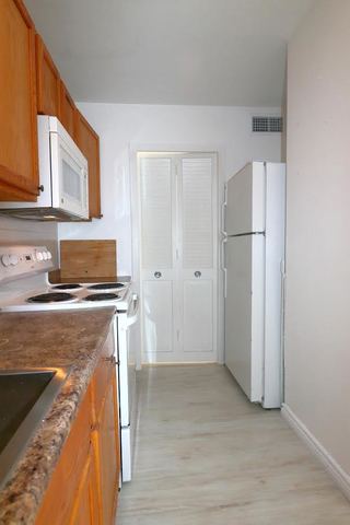 5701 North Sheridan Road, Unit 6P Chicago, IL 60660 - Photo 14 of 20 a kitchen with a refrigerator sink and cabinets