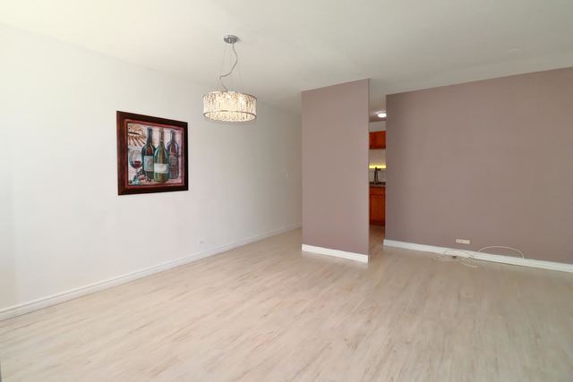 5701 North Sheridan Road, Unit 6P Chicago, IL 60660 - Photo 8 of 20 an empty room with wooden floor closet and windows
