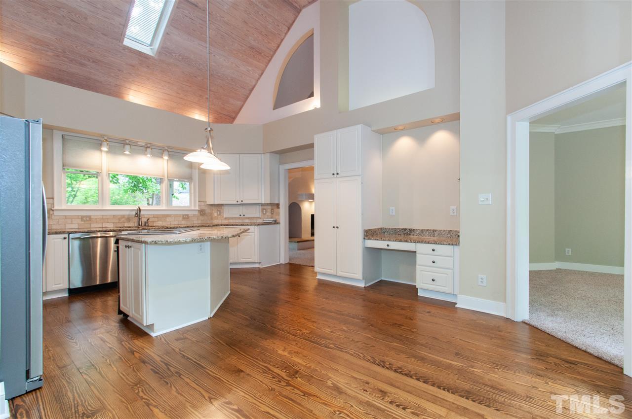 1700 Percheron Place Raleigh, NC 27613 - Photo 11 of 30 a kitchen with kitchen island a counter top space a sink stainless steel appliances and cabinets