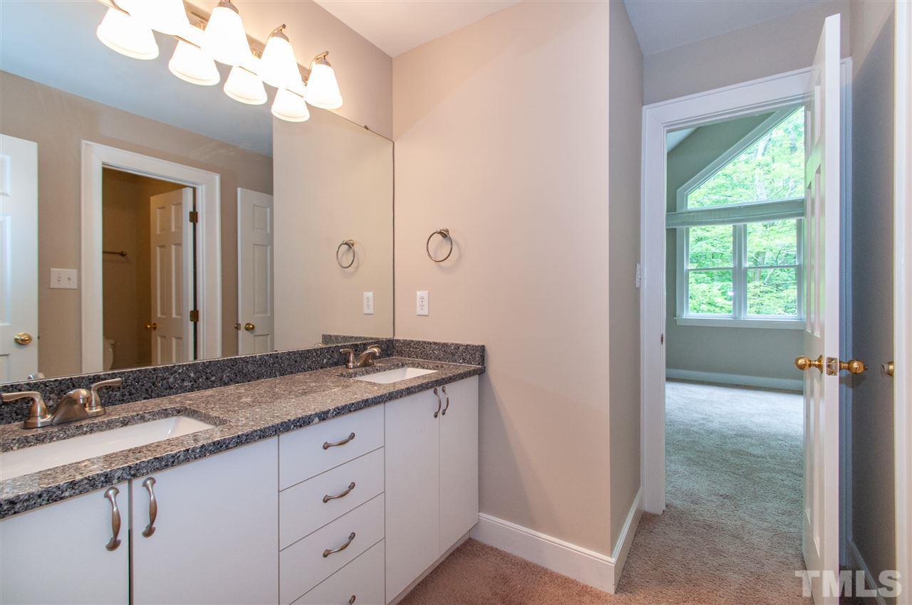 1700 Percheron Place Raleigh, NC 27613 - Photo 21 of 30 a bathroom with a granite countertop sink a large mirror and a light fixture