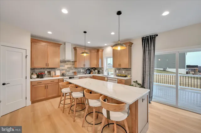 a kitchen with a table chairs stove and wooden floor