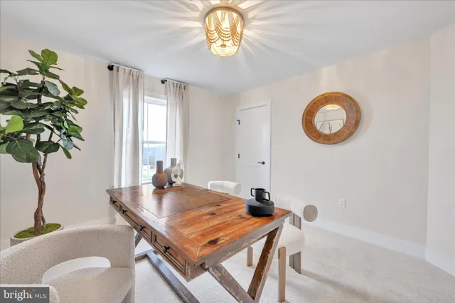 a view of a dining room with furniture and a potted plant