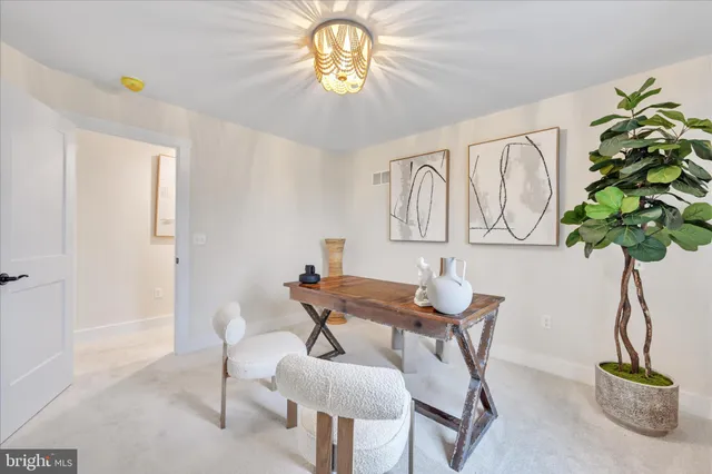 a view of a dining room with furniture and a potted plant