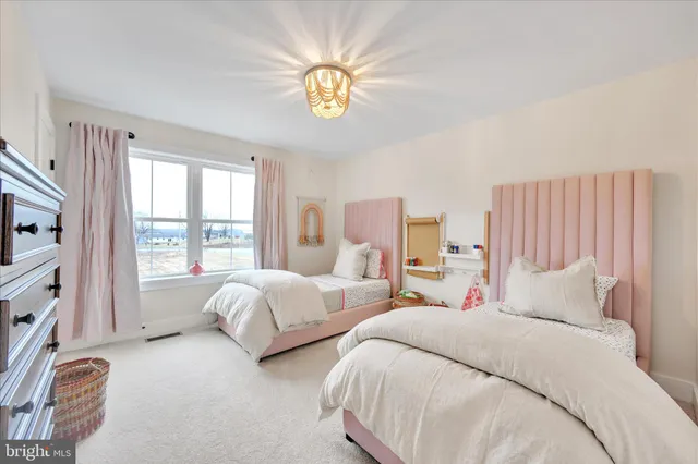 a bedroom with two beds and a large window