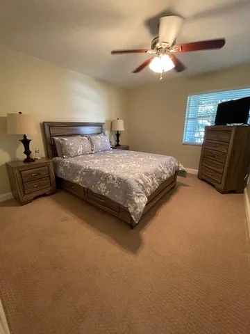 a bedroom with a bed and dresser with mirror