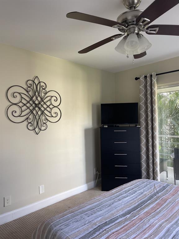 766 Normandy P, Unit 766 Delray Beach, FL 33484 - Photo 16 of 29 a room with a dresser and a ceiling fan